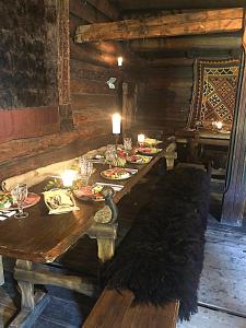 a long wooden table with plates of food on it at Jørundgard Vikingcamp in Sel