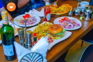 a table with plates of food and a sandwich and french fries at Vegas Chillout Suites in Kampala +18 photos