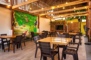 a restaurant with wooden tables and chairs and a tv at Hotel & Restaurante Siami in Leticia