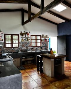 a large kitchen with black counter tops and windows at Sueño Verde EcoVilla in Cerro Verde