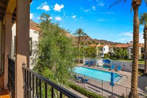 a balcony with a pool and palm trees at Poolside Greens 3BR Legacy Villa in La Quinta