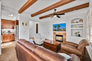 a living room with a leather couch and a kitchen at Poolside Greens 3BR Legacy Villa in La Quinta