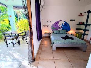 a bedroom with a bed with a fish painted on the wall at Casa Ceiba Samara in Sámara