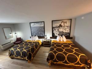 a hotel room with two beds and two pictures on the wall at Super 8 by Wyndham Sterling CO in Sterling