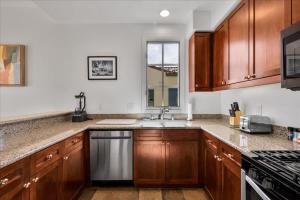 a kitchen with wooden cabinets and a sink at Poolside Greens 2BR Legacy Villa in La Quinta