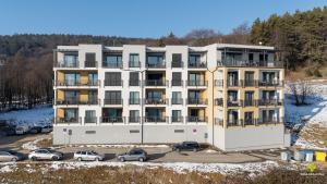 an apartment building with cars parked in a parking lot at Castle Studio 7 Bojnice in Bojnice