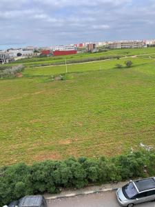 two cars parked in front of a field of grass at Appartement Moderne à Temara in Temara
