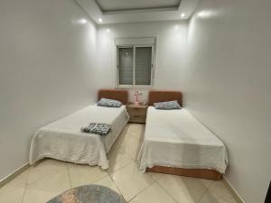 a room with two beds and a window at Appartement Moderne à Temara in Temara +5 photos