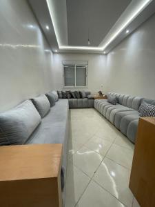 a living room with a long couch in a room at Appartement Moderne à Temara in Temara