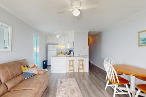 a living room with a couch and a table and a kitchen at NTBTR329 Totally Topsail in North Topsail Beach