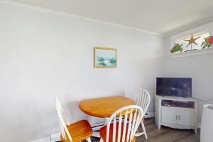 a room with a table and chairs and a television at NTBTR329 Totally Topsail in North Topsail Beach