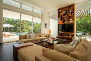 a living room with a couch and a tv at Villa Marazul 5BR Beach & Golf Access in Cancún