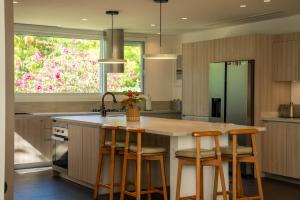 a kitchen with a large island with bar stools at Villa Marazul 5BR Beach & Golf Access in Cancún +52 photos