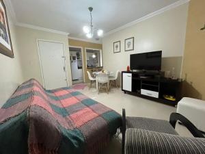 a bedroom with a bed and a tv and a table at AP perto do HSVP com estacionamento in Passo Fundo