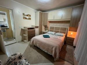 a small bedroom with a bed and a bathroom at AP perto do HSVP com estacionamento in Passo Fundo