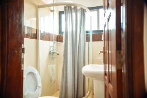 a bathroom with a shower and a toilet and a sink at Guest House Lumen in Lomé +77 photos