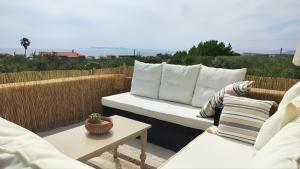 a white couch sitting on a patio with pillows at Georges Houses Mani in Riglia