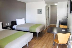 a room with two beds and a table and a desk at Motel 6 Augusta GA Fort Gordon in Augusta +18 photos