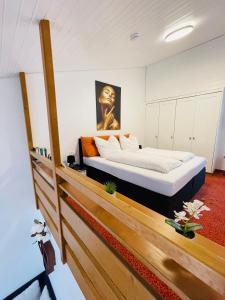 a bedroom with a bed with a painting on the wall at Das CLASSIQUE Galerieappartement 50qm - Elegant und geräumig wohnen - Espressomaschine, Airfryer, Balkon, Vierbeinerfreundlich, Parkgarage -AppHaus Poseidon in Bad Griesbach