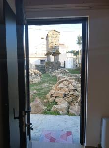 an open door with a view of a stone building at Pensión A Lubre in Fisterra