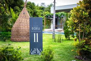 a sign in the grass in front of a house at Villa Egeu Praia da Pipa in Pipa