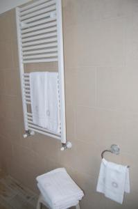 uma casa de banho com chuveiro, espelho e toalhas em B&B Il Salice em Borghesiana 