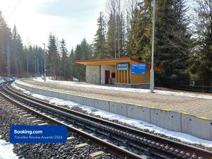 a train station with a platform with snow on the tracks at Apartman Point in Štrba