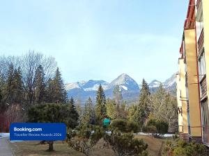 a sign in front of a building with mountains in the background at Apartman Point in Štrba