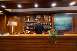 a man is sitting at a desk in a room at Hotel Vittoria in Porto Santo Stefano +43 photos