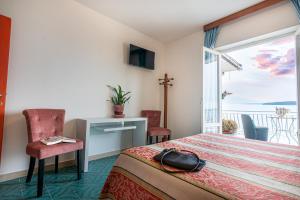 a hotel room with a bed and a balcony at Hotel Vittoria in Porto Santo Stefano