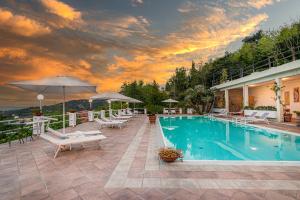 a swimming pool with chairs and umbrellas on a house at Hotel Vittoria in Porto Santo Stefano