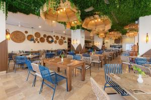 a dining room with tables and chairs and chandeliers at Villa 1 en Hotel Tesoro Ixtapa in Ixtapa