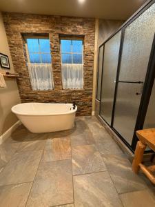 a bathroom with a tub and a glass shower at Yosemite's Inn the Woods in Ahwahnee +65 photos