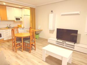 a living room with a table and a kitchen at Caballeros 7 in Soria