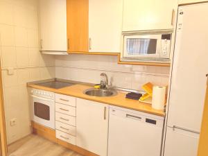 a small kitchen with a sink and a microwave at Caballeros 7 in Soria +8 photos