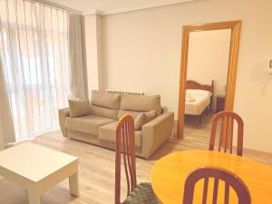 a living room with a couch and a table and a mirror at Caballeros 7 in Soria