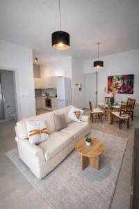 a living room with a white couch and a table at Twin Apartment in St. Julianʼs