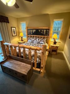a bedroom with a wooden bed with a bench in it at Yosemite's Inn the Woods in Ahwahnee