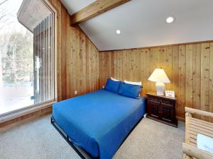 a bedroom with a blue bed and a window at Shoreline Chateau in Swanton