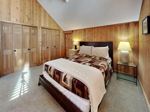 a bedroom with a large bed and wooden walls at Shoreline Chateau in Swanton +55 photos