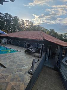 a house with a patio and a swimming pool at Chacara Recanto Mirella in Socorro