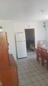 a kitchen with a refrigerator and a table and chairs at Casa Amarela in Imbituba