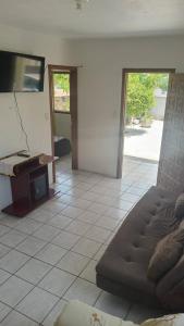a living room with a couch and a flat screen tv at Casa Amarela in Imbituba