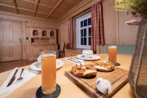 a table with bread and two glasses of orange juice at ღLIBORIA I Alpenblick Landhaus in Uffing