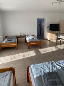 a room with two beds and a flat screen tv at Domek Ranczo in Mochnaczka Wyżna