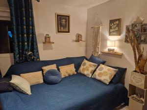 a blue couch with pillows in a living room at Harmonie in Blésignac