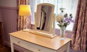 a dressing table with a mirror and a vase of flowers at Sibton White Horse Inn in Saxmundham +35 photos
