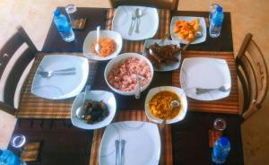 a table with white plates of food on it at Villa 188 Yala in Tissamaharama +18 photos