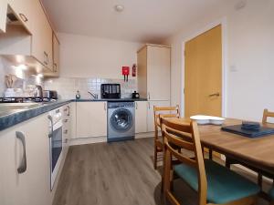 a kitchen with a wooden table and a dining room at Ness-Side Apartment in Inverness