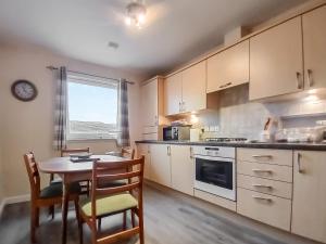 a kitchen with a table and chairs and a dining room at Ness-Side Apartment in Inverness